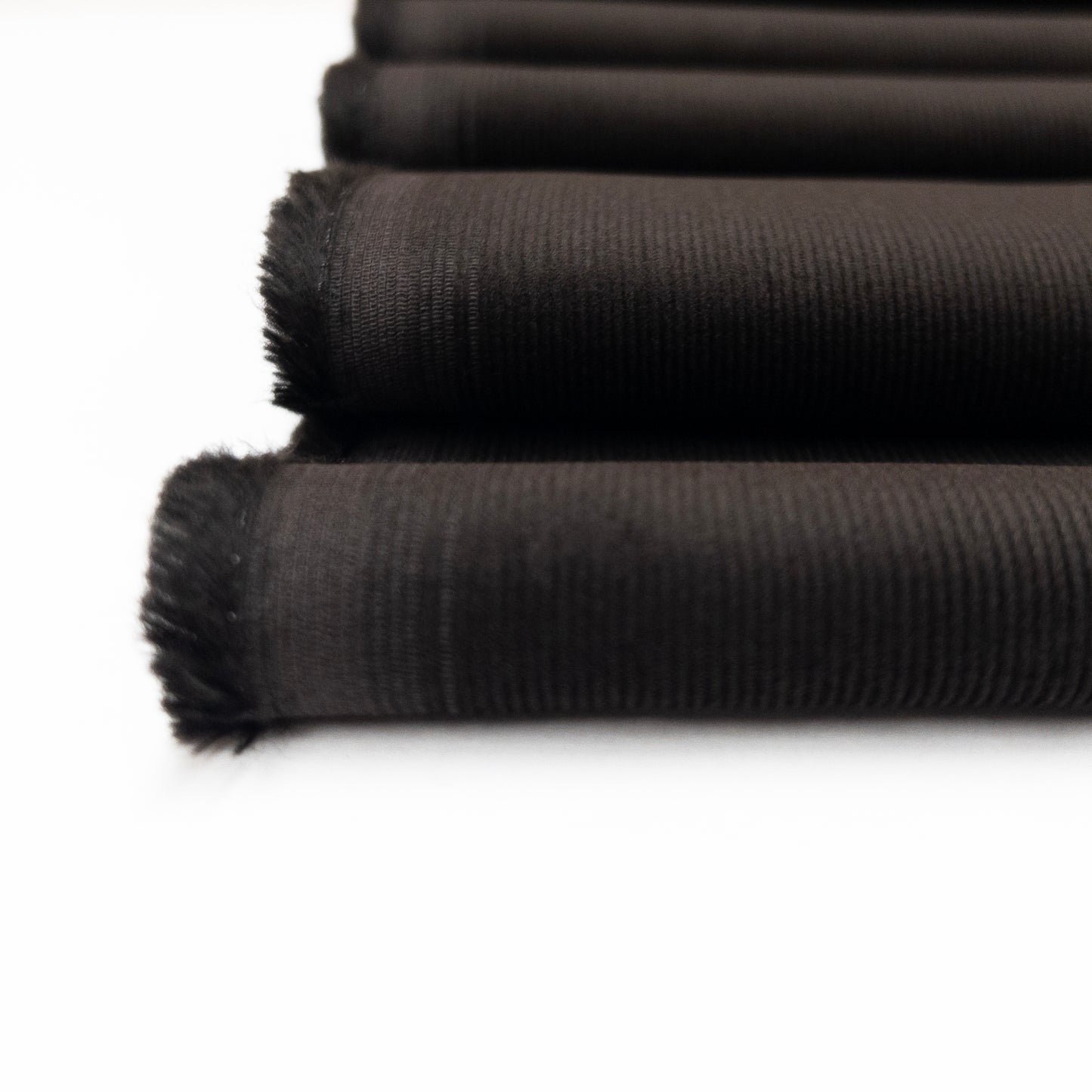 Detail view of fine corduroy ribs on this organic cotton apparel fabric in dark brown